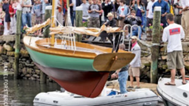 A Herreshoff 12 1/2-footer is lowered into the water at the International Yacht Restoration School's graduation ceremony. Fourteen students graduated from the Boatbuilding & Restoration program this year; 12 from the Marine Systems program.