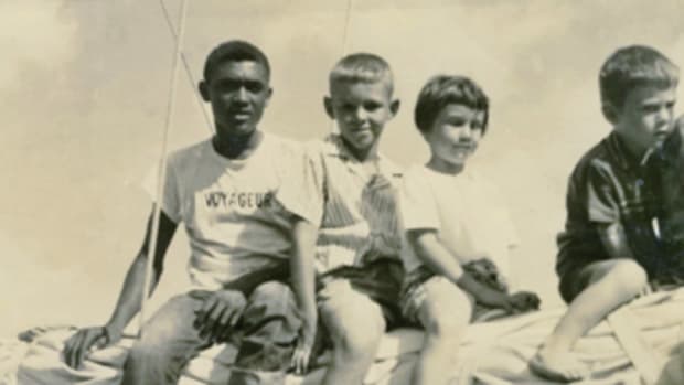 Deckhand Joe Cranston, Lou Boudreau, and his siblings Janene and Peter, on the boom of the schooner Ramona.