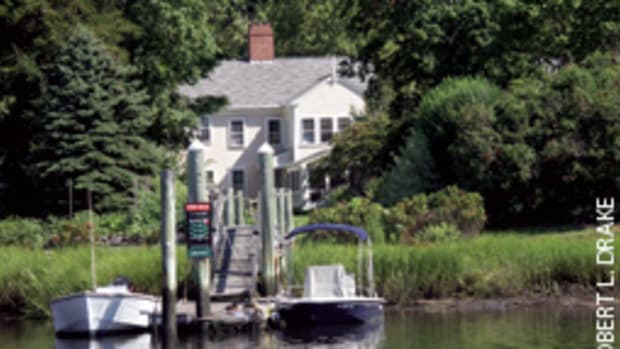 The private dock of the 1802 home in Wickford, R.I.,'s National Historic District accommodates the owners' center console runabout (right) and a neighbor's fishing skiff.