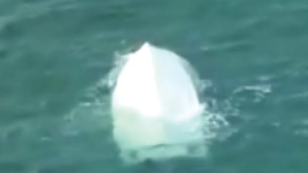 An image from a Coast Guard video shows the capsized 25-foot center console.