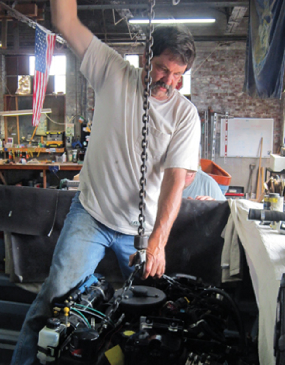 Marine mechanic Erik Klockars guides the new MerCruiser engine into place — it delivers a boost of 100 hp and 15 mph.