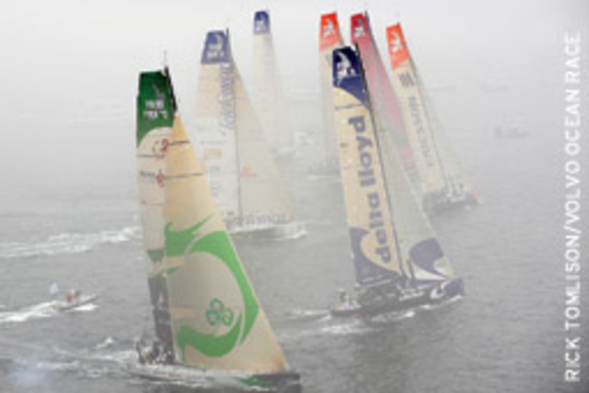 The Volvo Ocean Race fleet, covered in fog, sails in the Boston in-port race at Fan Pier.