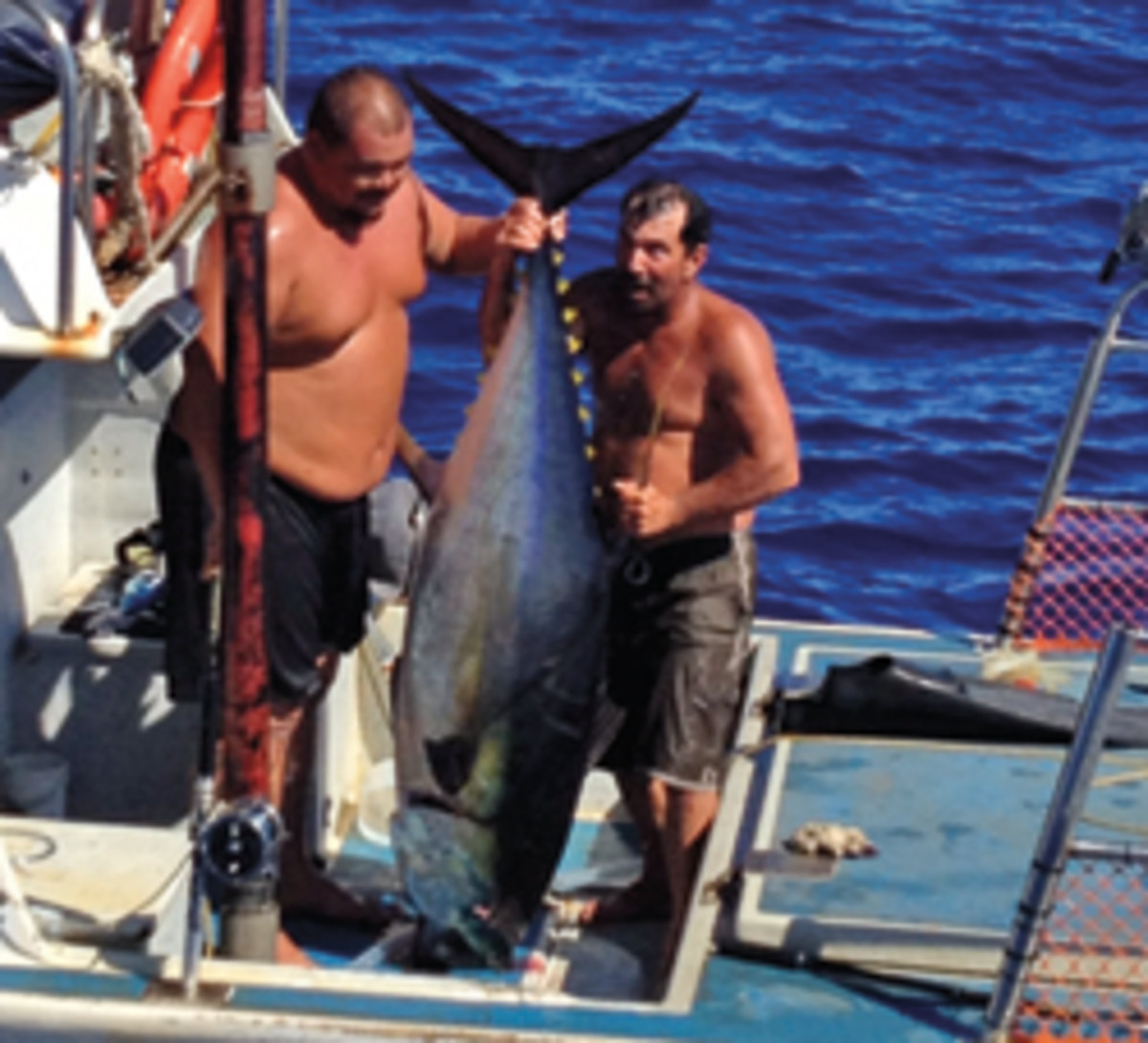 Fishing buddies Jordon Ornellas and Abraham Apilado revel in their friend’s catch.