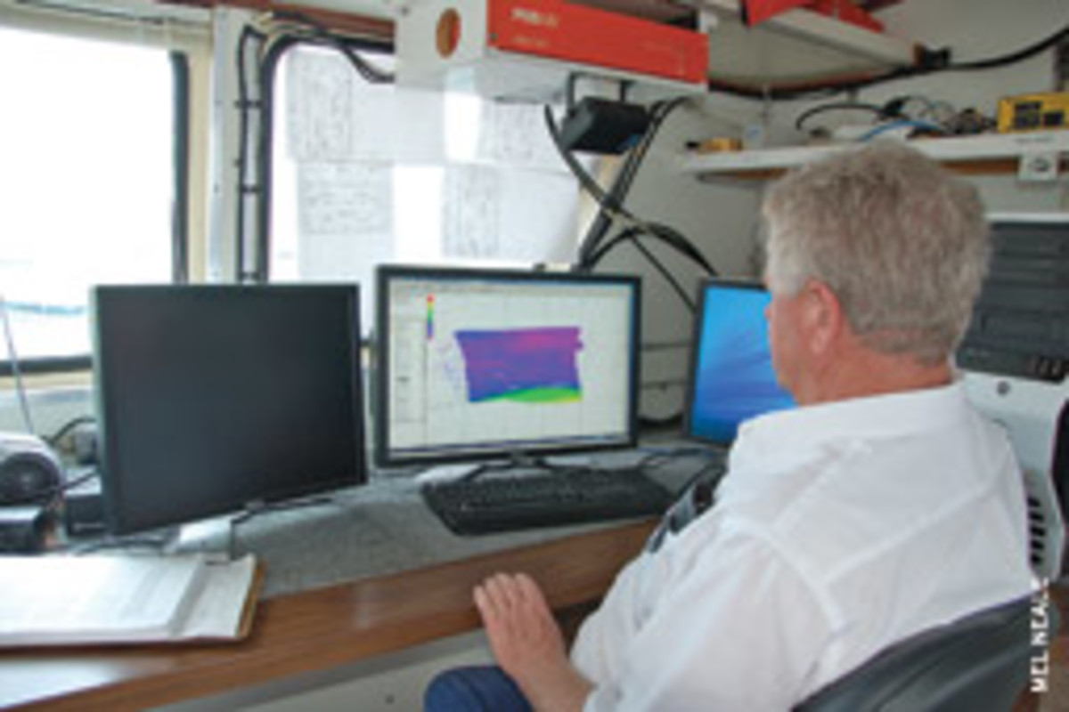 Army Corp of Engineers surveyor Tommy Thomas attends to business in his office aboard the survey vessel Florida.