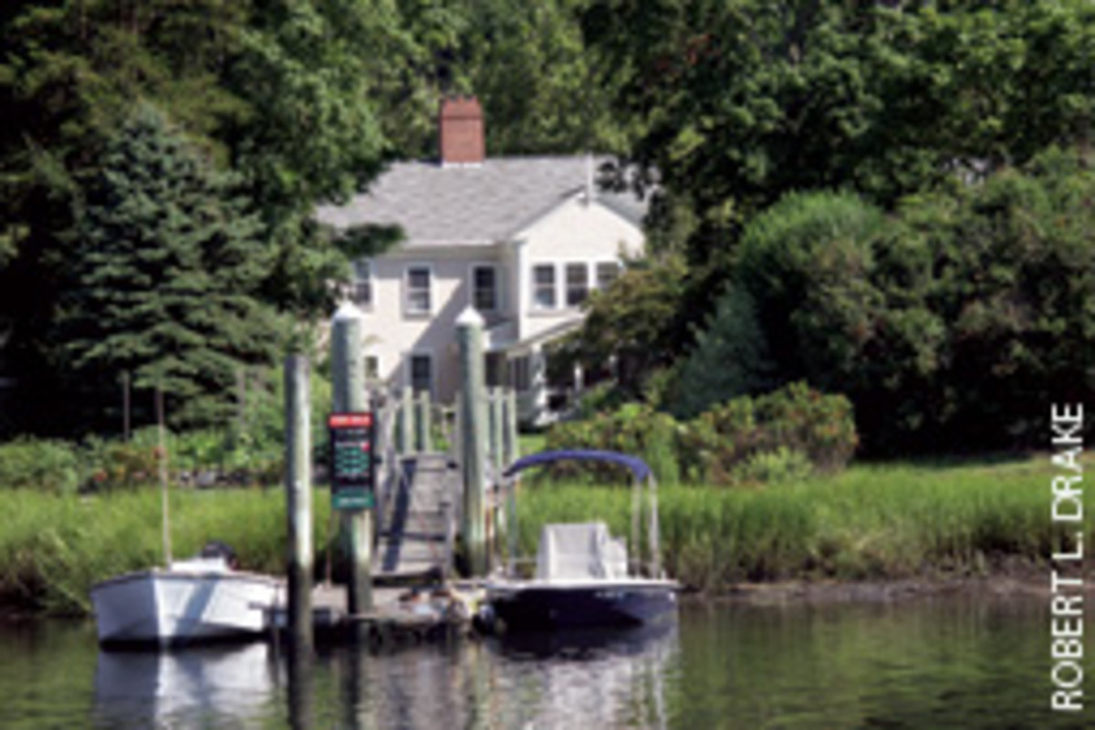 The private dock of the 1802 home in Wickford, R.I.,'s National Historic District accommodates the owners' center console runabout (right) and a neighbor's fishing skiff.
