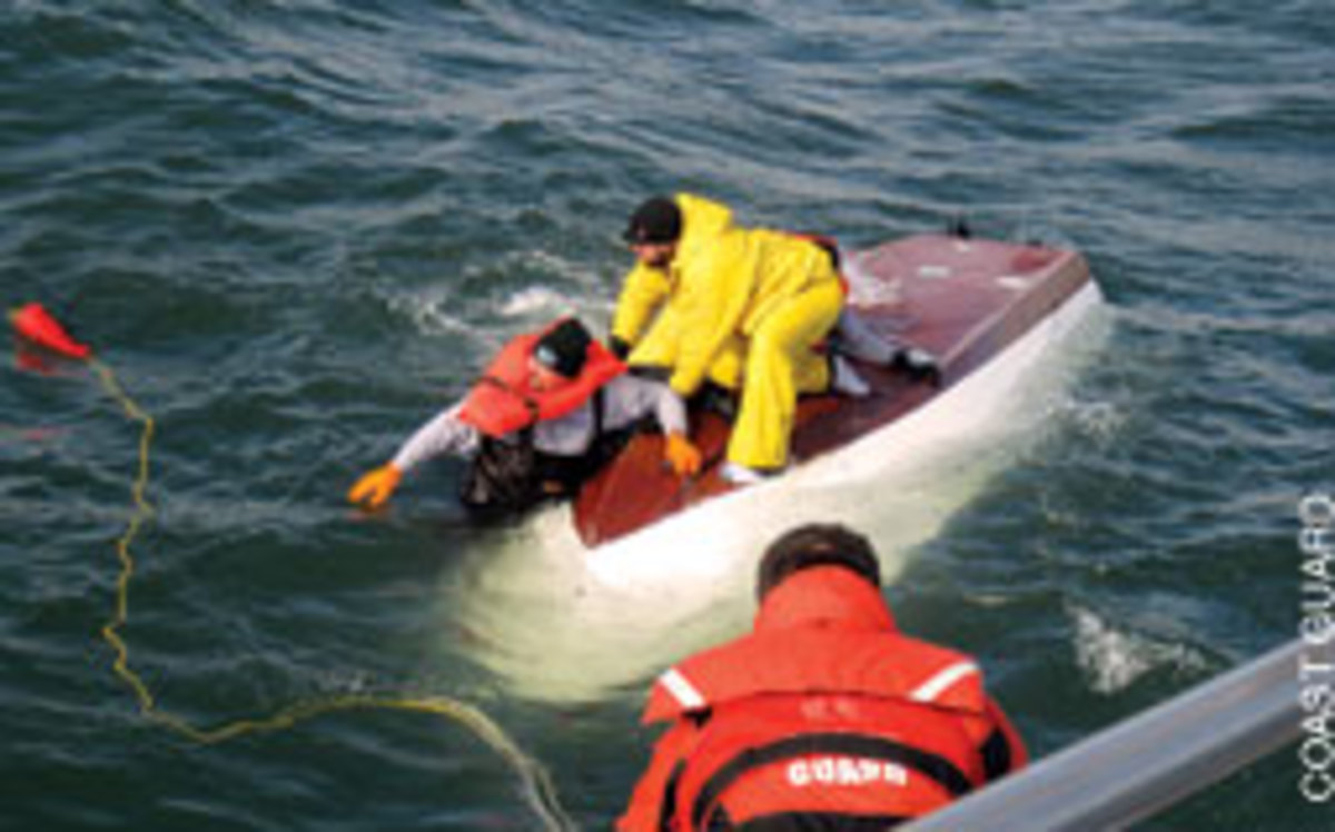 A Coast Guard rescue boat crewmember from Station Manasquan Inlet, N.J., throws a heaving line Nov. 6 to a man on a capsized 17-foot boat one nautical mile off Point Pleasant.