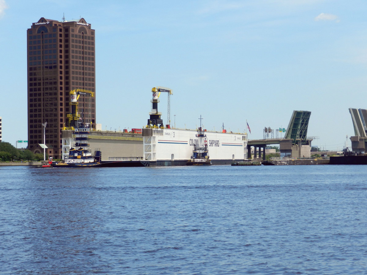 Photo of  a tight fit when tugs finessed a floating dry dock through the Berkley Bridge, bound for Colonna’s Shipyard.
