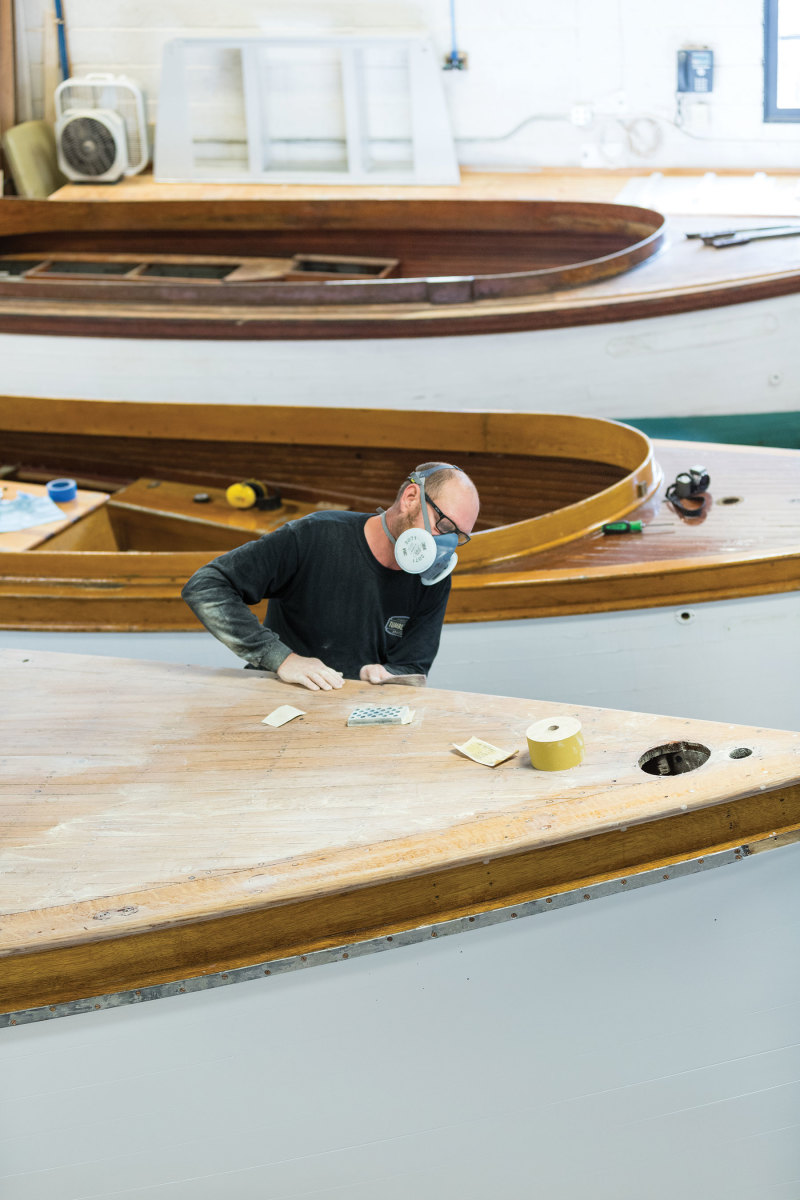 A craftsman works the wood on a 36-foot Elco fantail electric launch built in 1896.