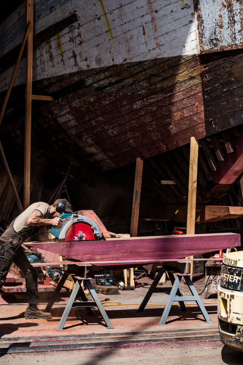 Peter Stein saws a purpleheart beam for the Western Flyer restoration.