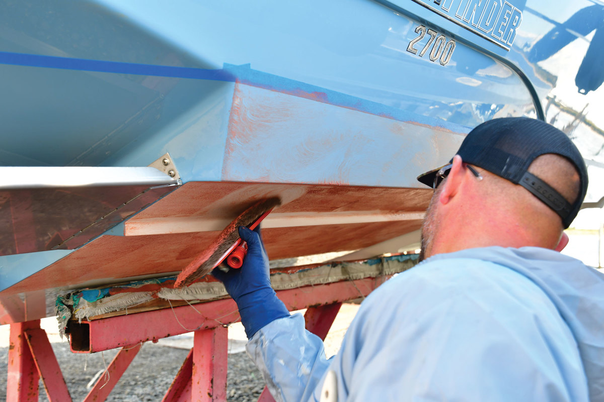 Interlux Surface Prep is applied to the boat’s surface and then rinsed off.