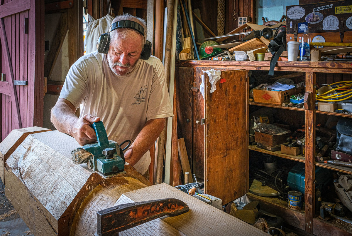 Master Shipwright Frank Townsend planes the drum for the windlass assembly