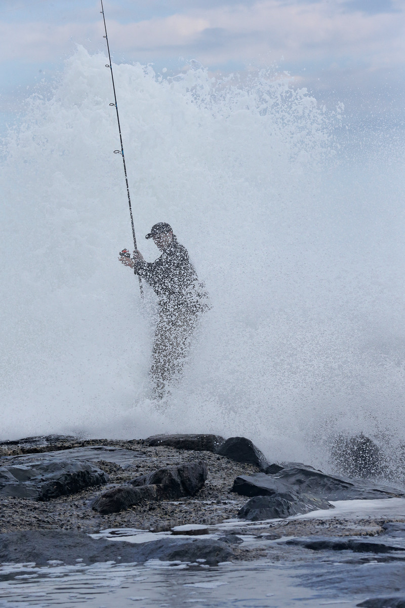 An angler gets a dousing in the surf while on the hunt for stripers. 